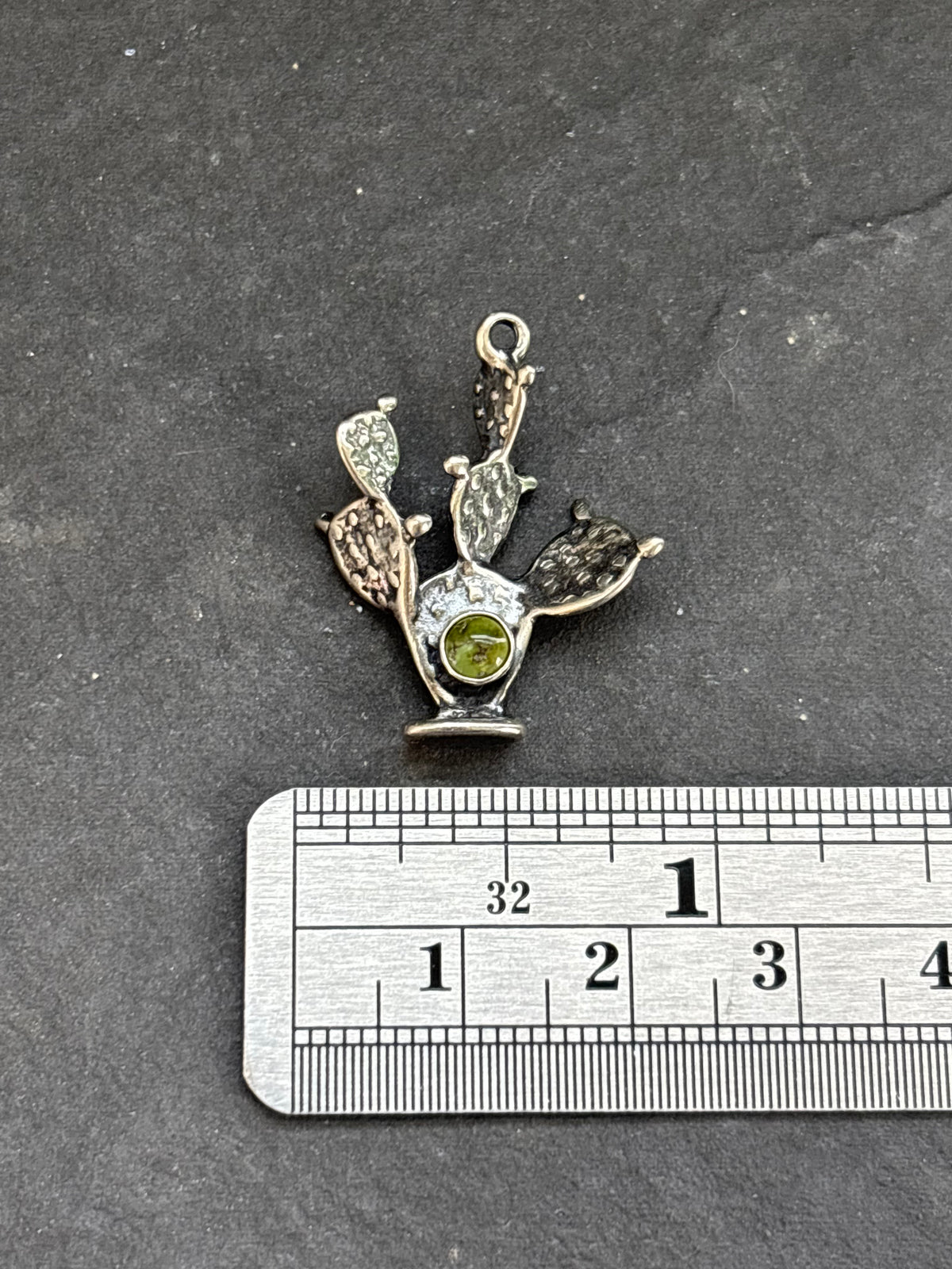Sonoran Gold Prickly Pear Cactus Charm in sterling silver, beside a horizontal ruler for scale
