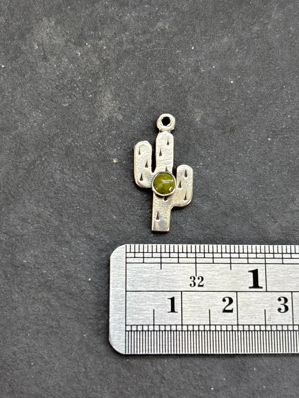 Sonoran Gold Saguaro Cactus Charm in sterling silver, beside a horizontal ruler for scale
