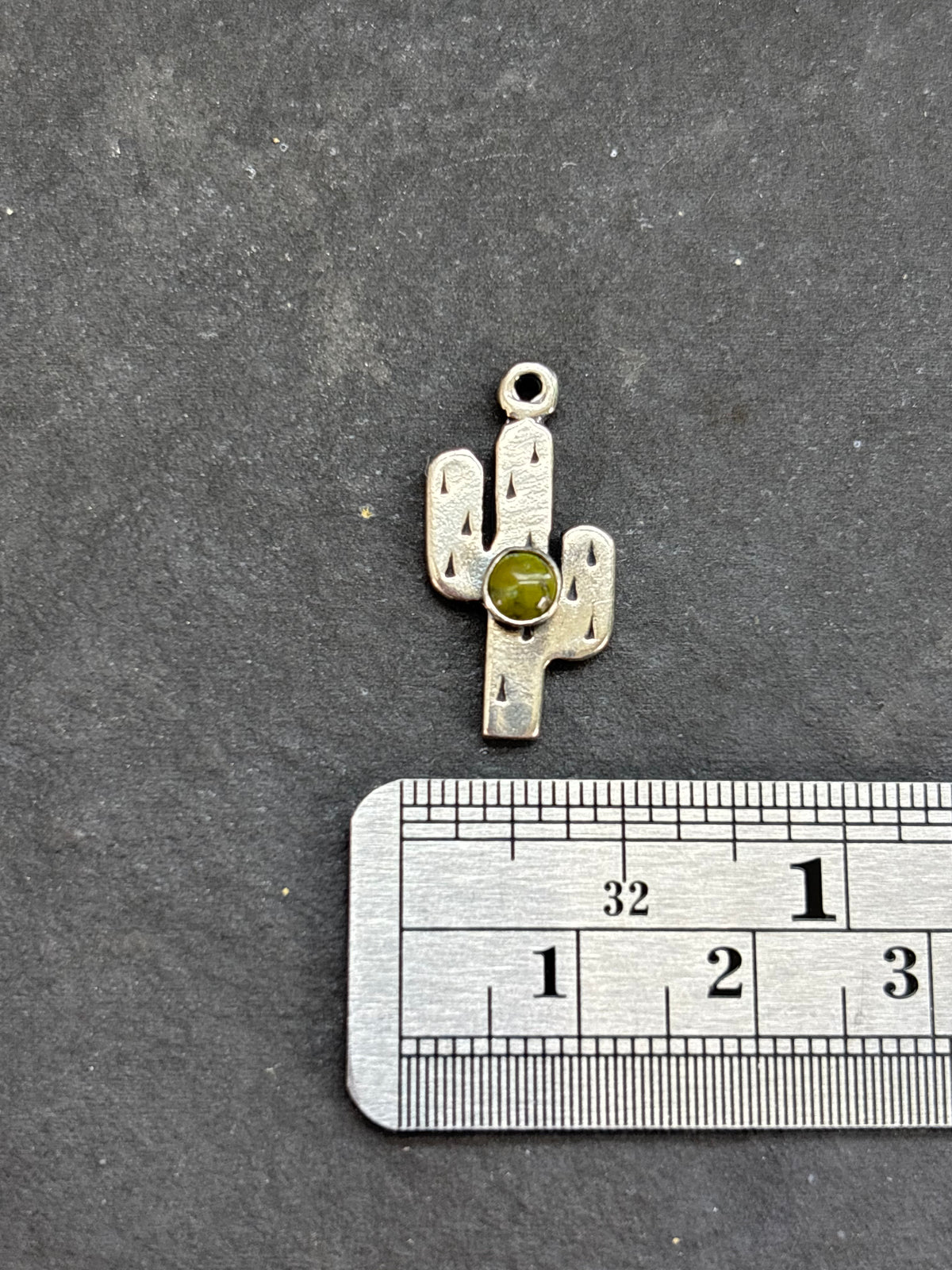 Sonoran Gold Saguaro Cactus Charm in sterling silver, beside a horizontal ruler for scale