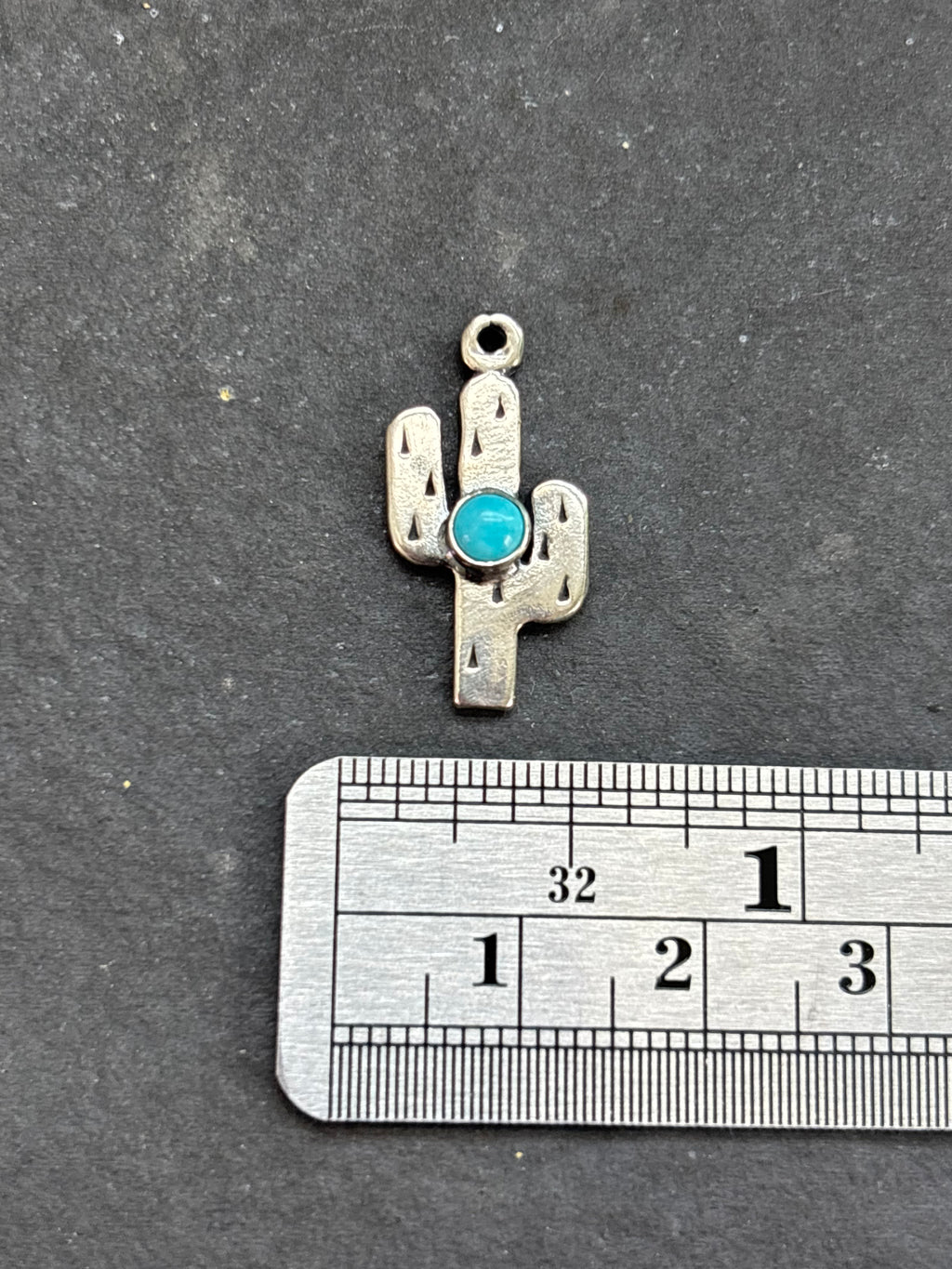 Light Blue Kingman Turquoise Saguaro Cactus Charm in sterling silver, beside a horizontal ruler for scale