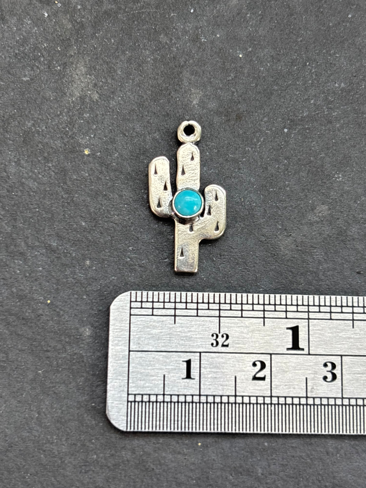 Light Blue Kingman Turquoise Saguaro Cactus Charm in sterling silver, beside a horizontal ruler for scale