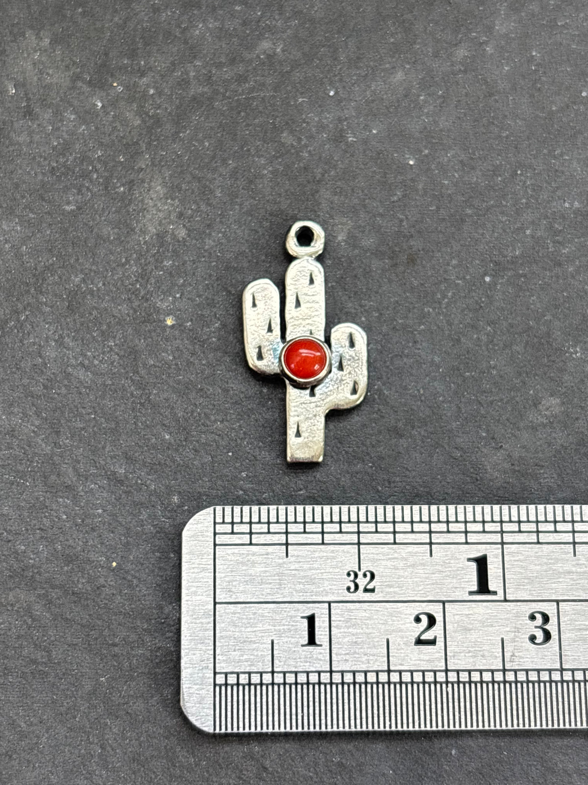Red Spiny Oyster Saguaro Cactus Charm in sterling silver, beside a horizontal ruler for scale