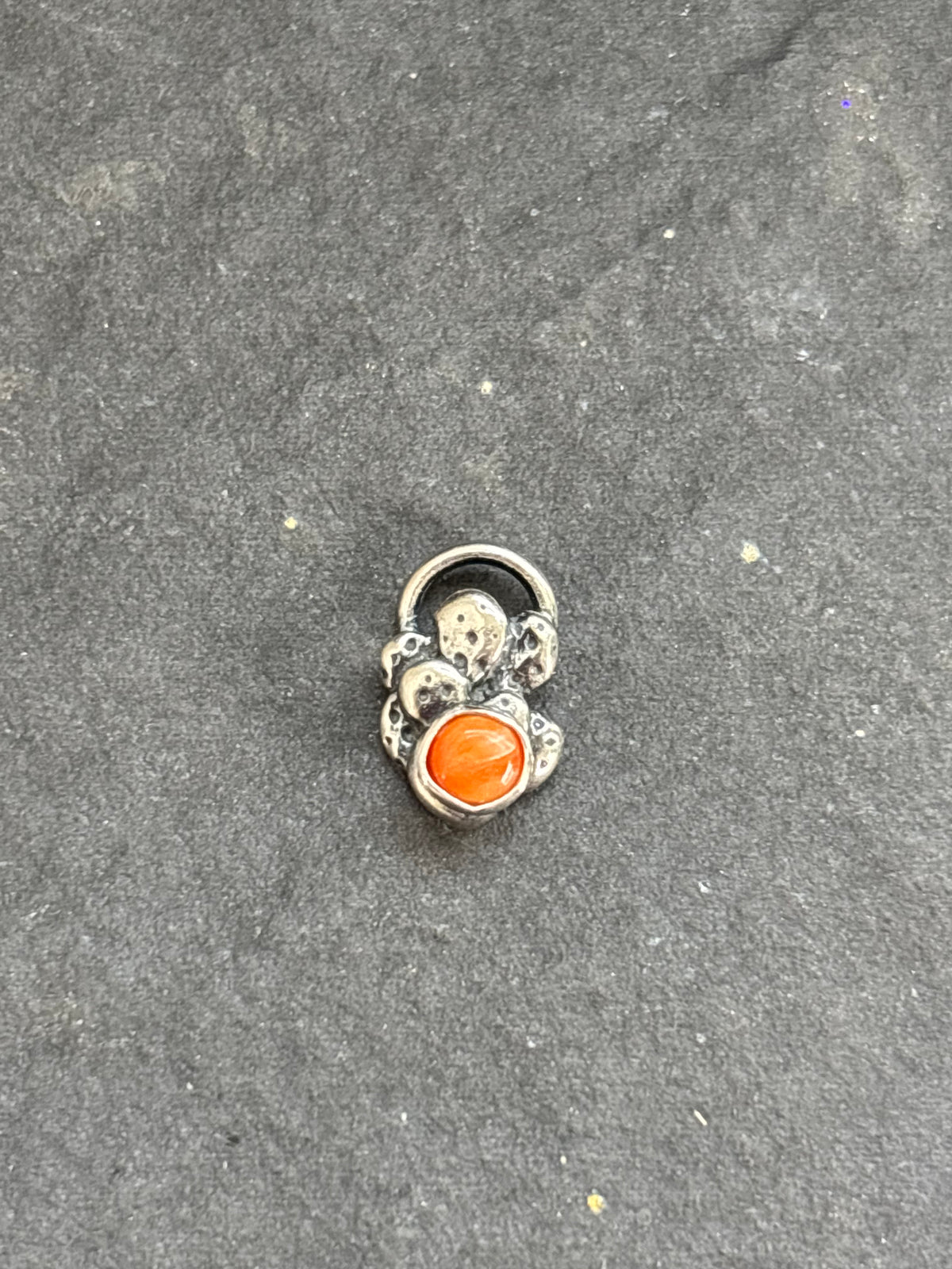 Front of a sterling silver Baby Prickly Pear Cactus Charm with orange spiny oyster.