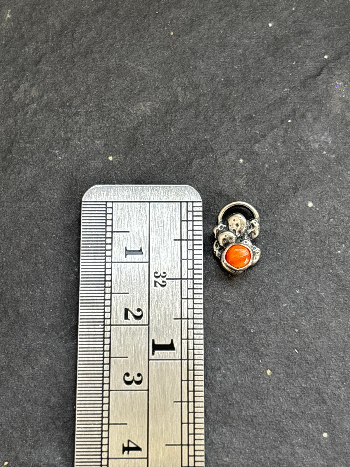 Sterling silver Baby Prickly Pear Cactus Charm with orange spiny oyster beside a vertical ruler for height reference.