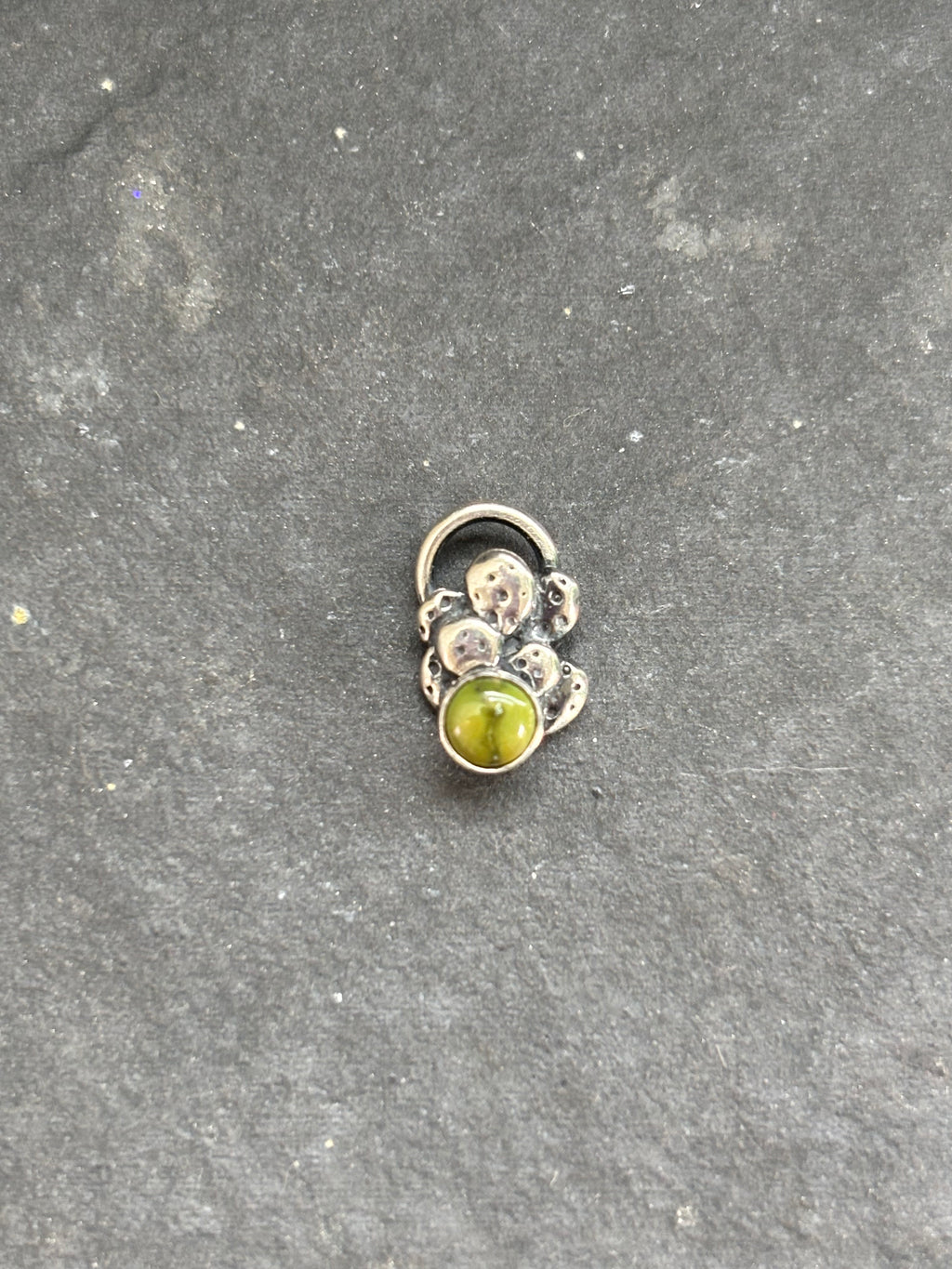 Front of a sterling silver mini cactus charm with a green Sonoran Gold stone.