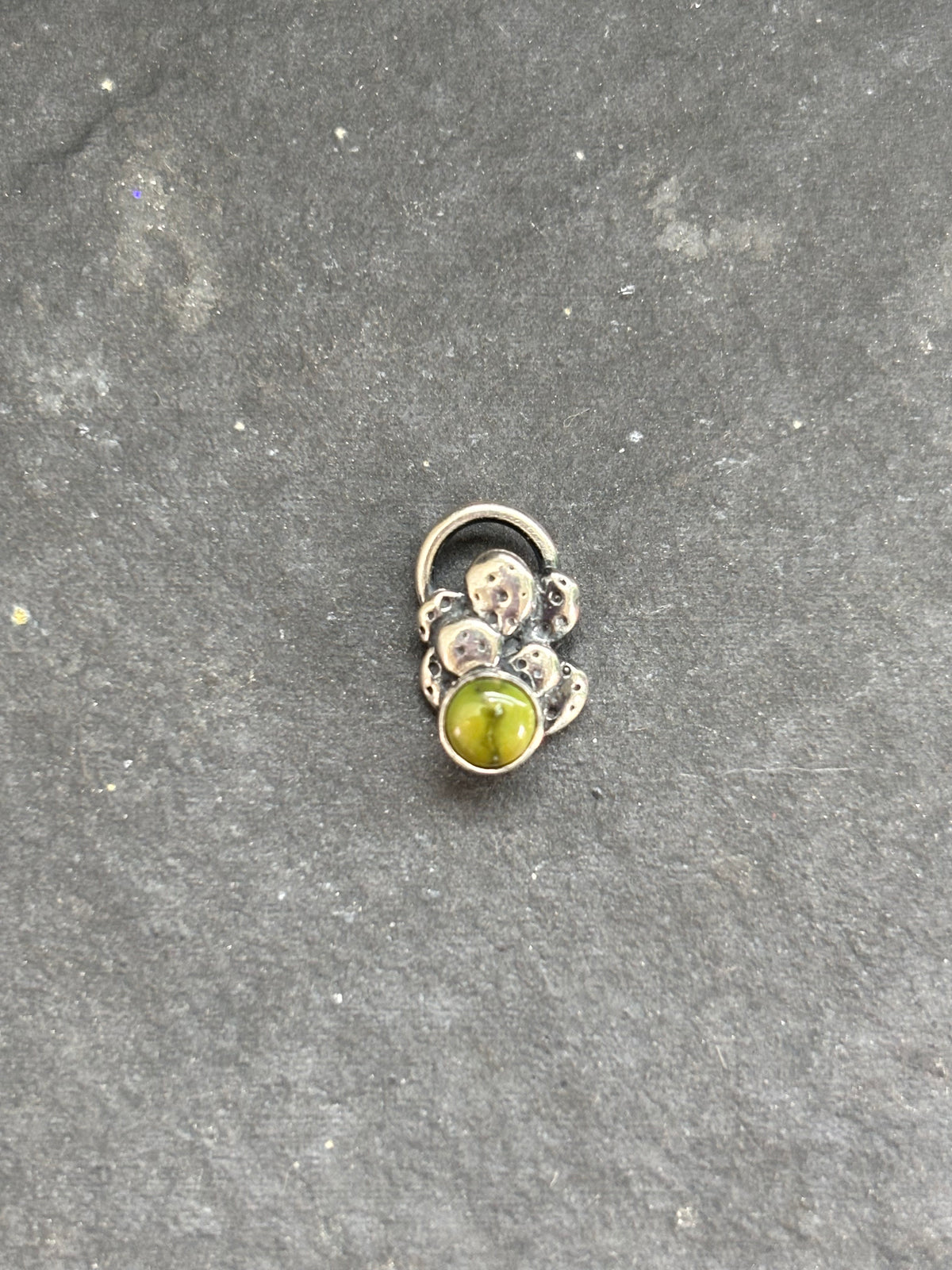 Front of a sterling silver mini cactus charm with a green Sonoran Gold stone.