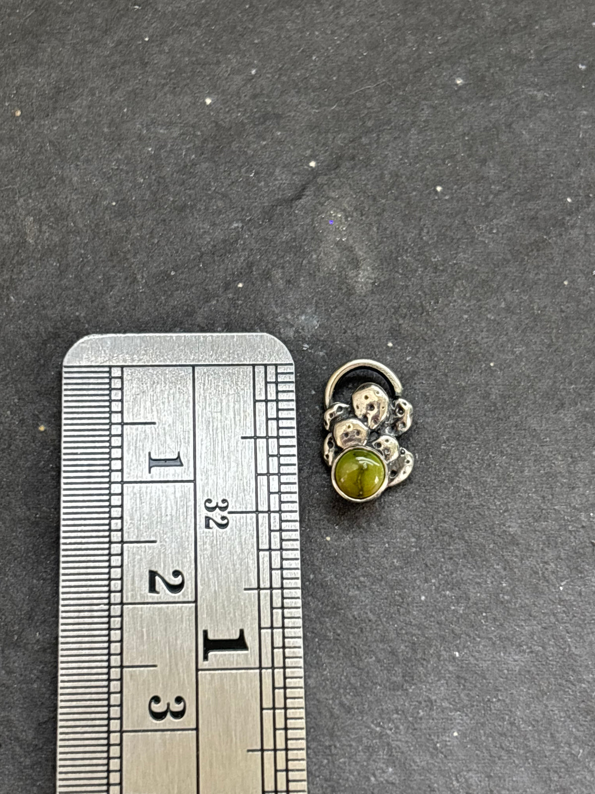 Sterling silver Sonoran Gold mini cactus charm beside a vertical ruler for height reference.
