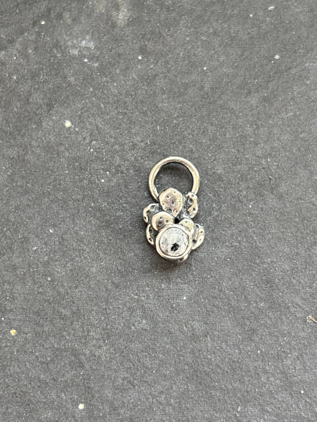 Front of a sterling silver Baby Prickly Pear Cactus Charm with White Buffalo.