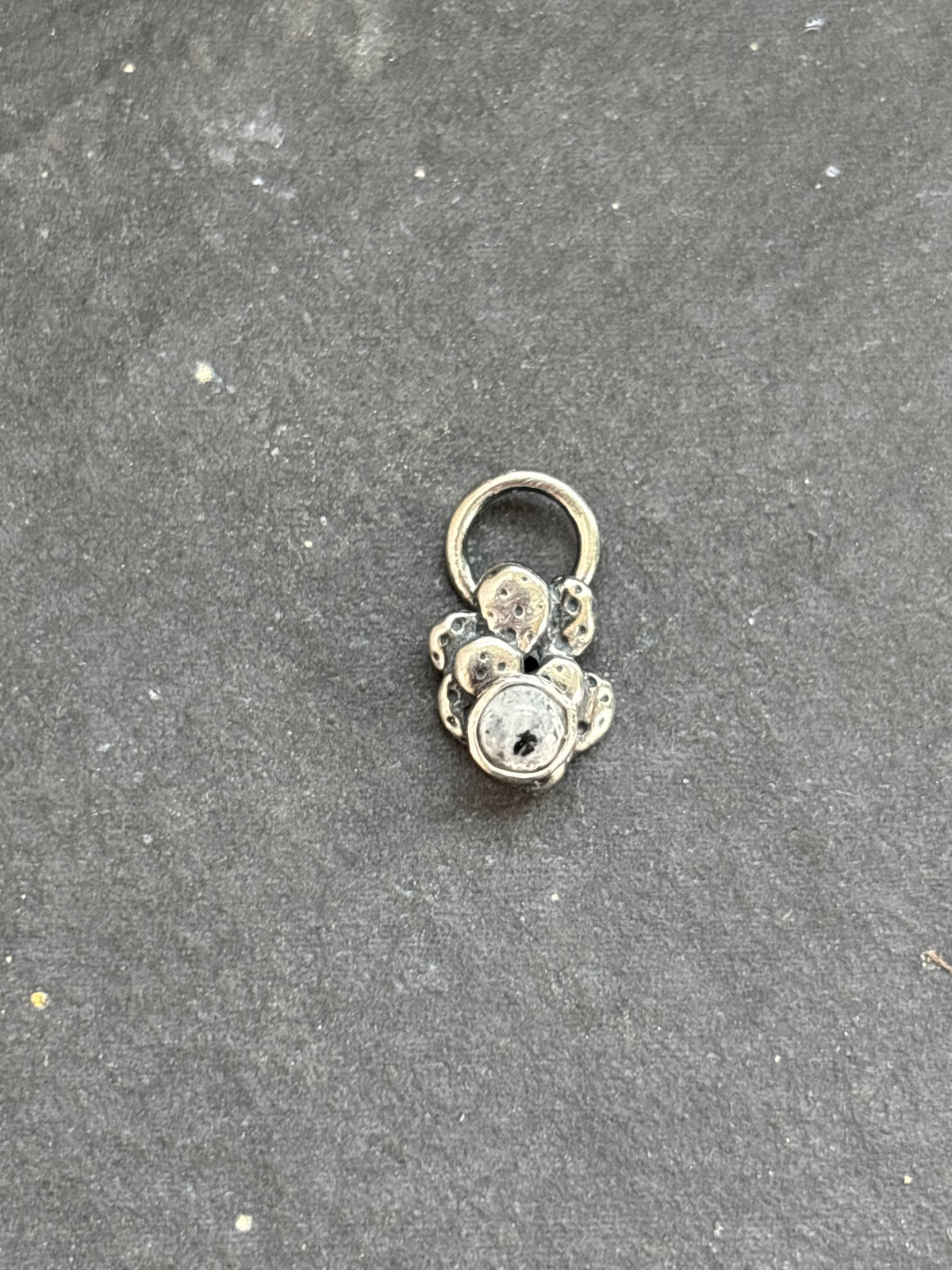 Front of a sterling silver Baby Prickly Pear Cactus Charm with White Buffalo.