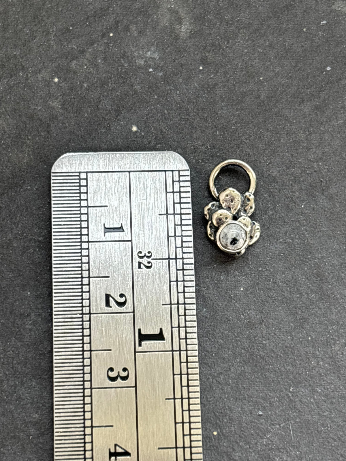 Sterling silver Baby Prickly Pear Cactus Charm with White Buffalo beside a vertical ruler for height reference.