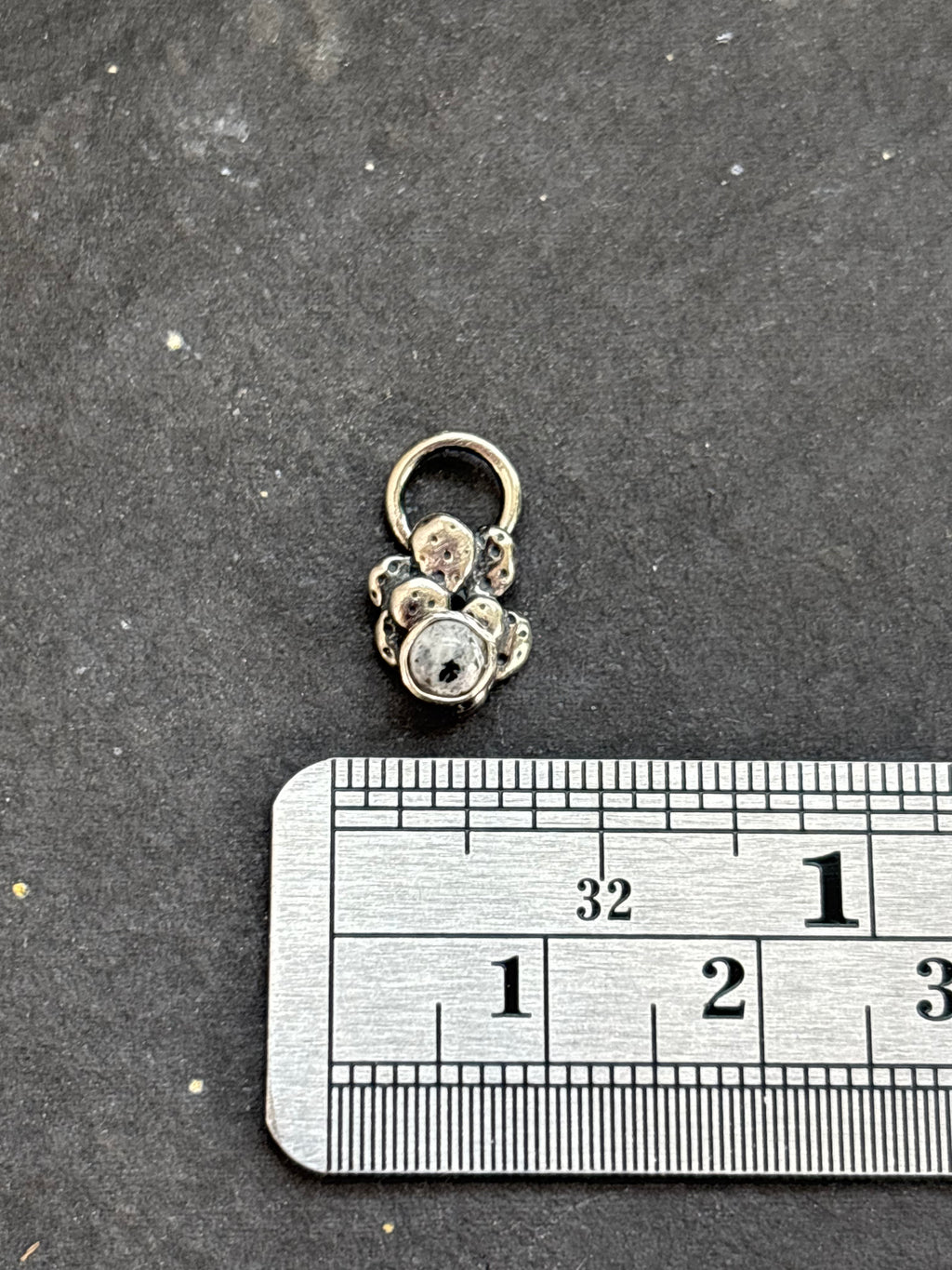 Sterling silver Baby Prickly Pear Cactus Charm with White Buffalo above a horizontal ruler for width reference.